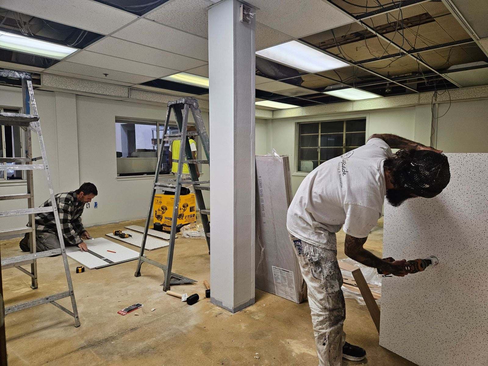 Painter patching wall board during a commercial renovation