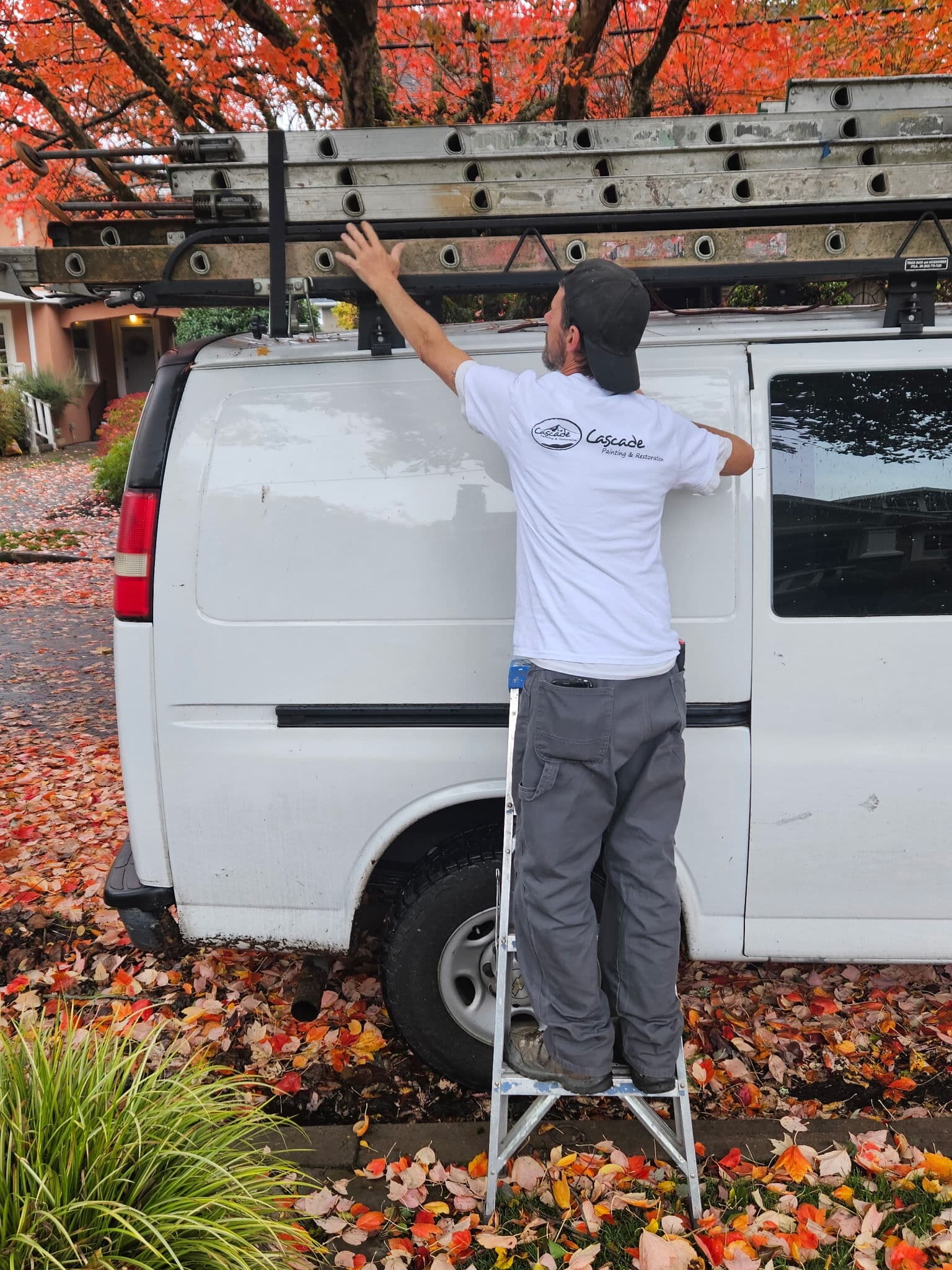 Cascade painter loading ladders onto the work van on an autumn day