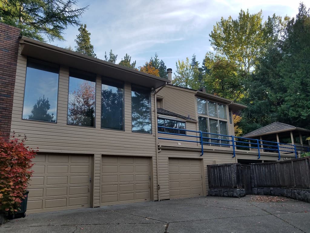 Two-story home with tan siding and three garage doors