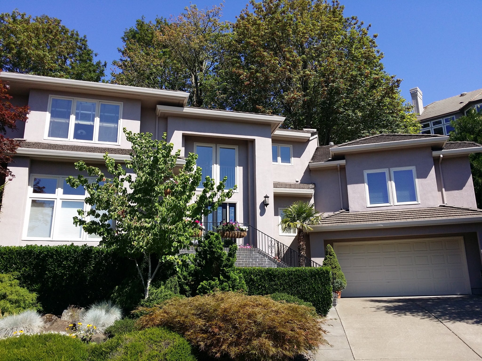 Finished exterior repaint of a timber-and-stone home